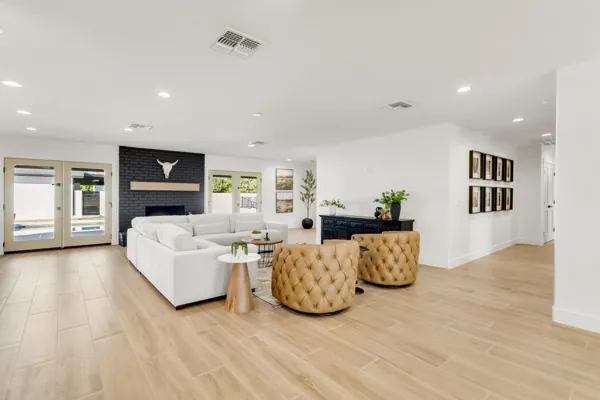 Spacious modern living room with stylish furniture, a dark brick fireplace, and natural light, showcasing real estate photography in Phoenix, AZ.
