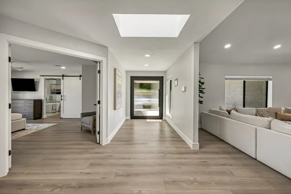 This stunning real estate photography captures a modern hallway leading to a living room with stylish decor in Scottsdale, AZ.