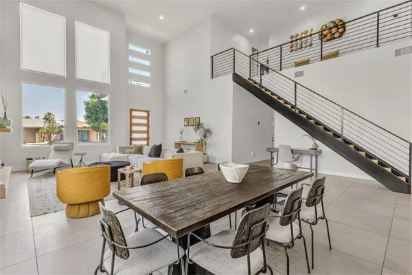 This modern living room in Scottsdale, AZ features high ceilings and an open staircase, perfectly captured with professional real estate photography to highlight the home's spacious design.