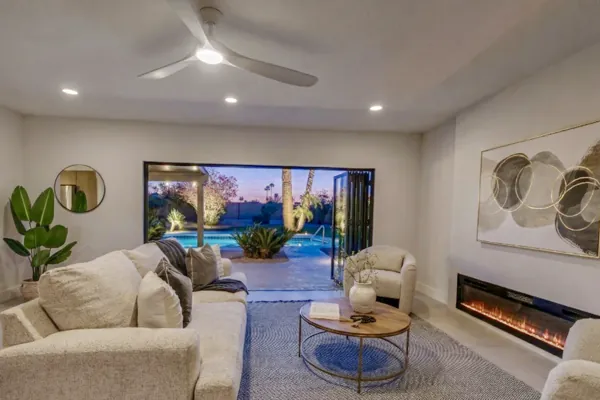 This Scottsdale, AZ living room features an open view to the pool area in the evening, showcasing elegant decor and modern real estate photography capturing the cozy ambiance.