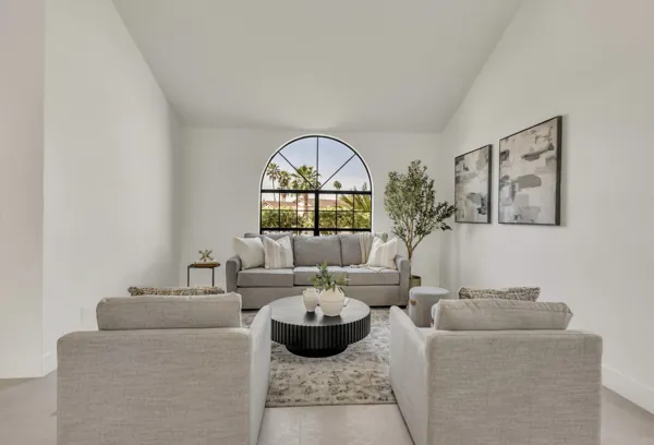 This modern living room with an arched window offers bright and elegant space, showcased through expert real estate photography in Scottsdale, AZ.