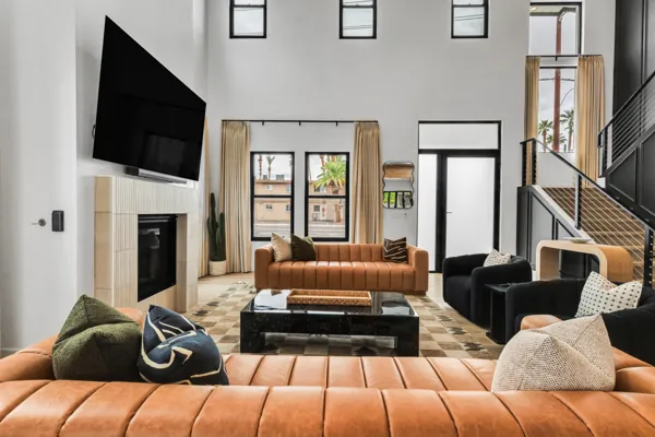 This Scottsdale, AZ living room features modern design with high ceilings, leather sofas, large windows, and sleek decor, captured beautifully in real estate photography.