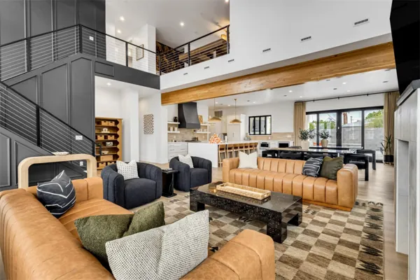 Spacious modern living room with open concept kitchen and dining area in Scottsdale, AZ, showcased through professional real estate photography capturing stylish furniture and architectural details.