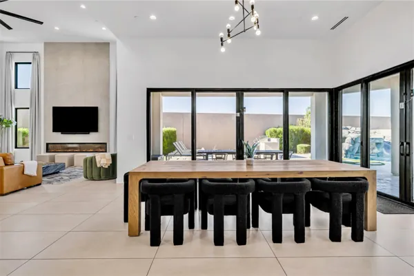 This modern dining room and living area in Scottsdale, AZ features large windows, stylish furnishings, and abundant natural light, captured with expert real estate photography.