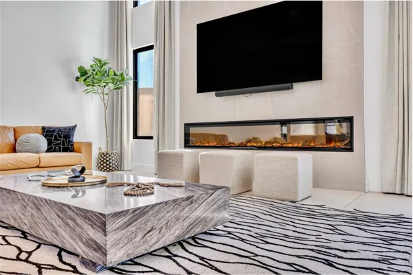This modern living room in Scottsdale, AZ features a sleek fireplace, marble coffee table, and elegant decor, captured with professional real estate photography to highlight the home's stylish interior.