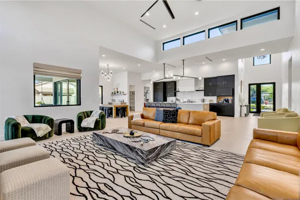 This modern open living room and kitchen in Scottsdale, AZ showcases sleek design and spacious comfort, perfect for luxurious living, captured with expert real estate photography.