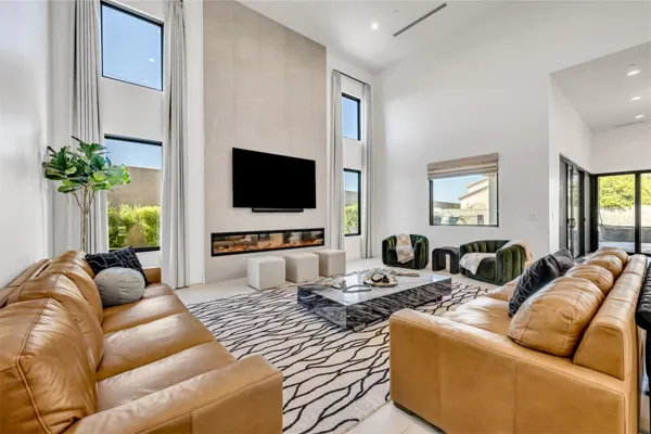 This spacious living room in Scottsdale, AZ features modern design with a sleek fireplace, large windows, and luxurious seating, captured perfectly for real estate photography.