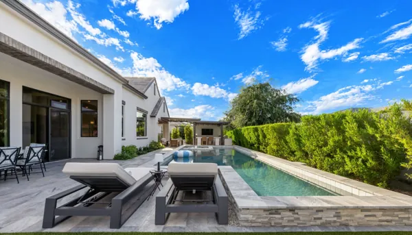 Experience luxury real estate photography showcasing a stunning poolside retreat in Gilbert, AZ, featuring modern patio design and lush landscaping for ultimate relaxation.