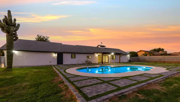 This Mesa, AZ home features a spacious backyard with a glowing pool at sunset, captured beautifully through expert real estate photography.