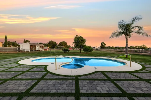 This Mesa, AZ property features a beautiful swimming pool and patio area perfect for outdoor relaxation, captured in professional real estate photography during a stunning sunset.