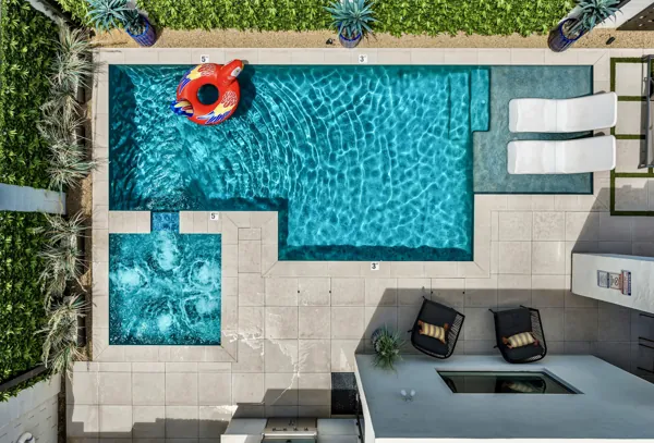 This aerial real estate photography showcases a pristine pool and jacuzzi with loungers in a Scottsdale, AZ backyard, perfect for relaxation and outdoor enjoyment.