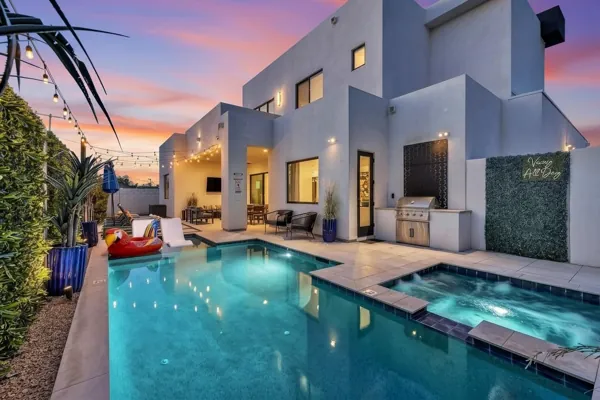 Stunning modern home exterior with pool and backyard in Scottsdale, AZ captured through professional real estate photography at sunset.
