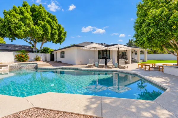Explore exquisite real estate photography showcasing a stunning backyard oasis in Scottsdale, AZ, capturing an inviting pool area with lush greenery.