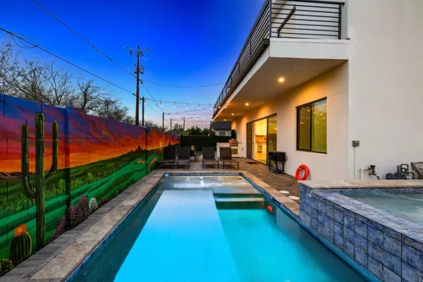 Stunning real estate photography showcasing a pool and patio area with a vibrant mural in Scottsdale, AZ, perfect for evening relaxation and entertaining.