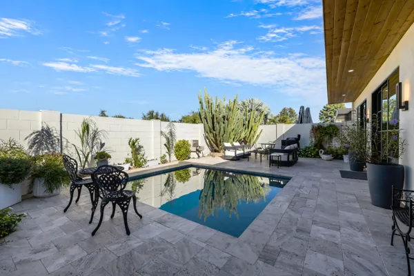 Experience luxury real estate photography with this exquisite Scottsdale, AZ backyard showcasing a pristine pool and elegant patio furniture.
