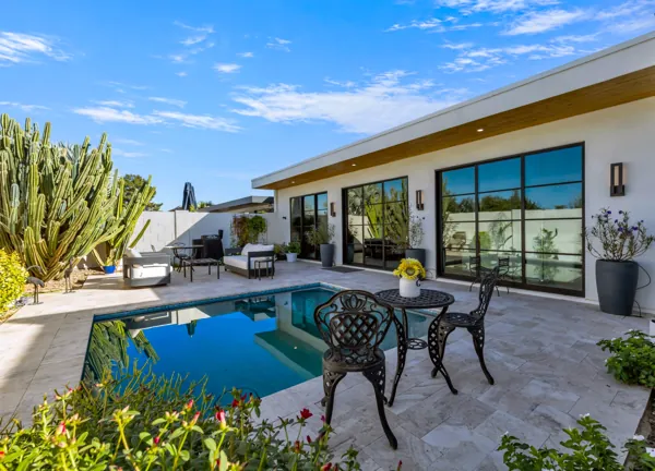 This luxury real estate photography captures a stunning modern patio in Scottsdale, AZ, featuring a pool and beautiful cactus landscaping.