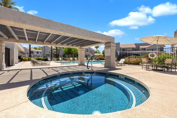 Spacious condo complex with hot tub and pool amenities in Scottsdale, AZ showcasing beautiful outdoor living spaces.