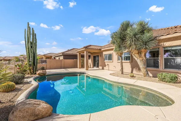 Beautiful backyard with a desert-style pool and landscaping captured in real estate photography in Scottsdale, AZ.