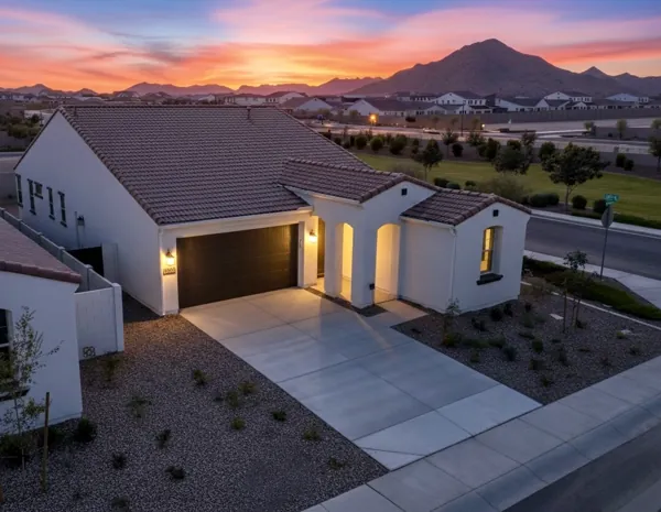 This twilight real estate photography showcases a beautifully lit suburban home in Phoenix, AZ with mountain views and well-maintained landscaping, perfect for buyers seeking tranquility and style.
