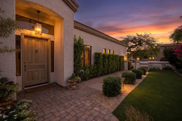 Beautiful sunset real estate photography showcasing the exterior entrance and landscaped yard of a home in Scottsdale, AZ.
