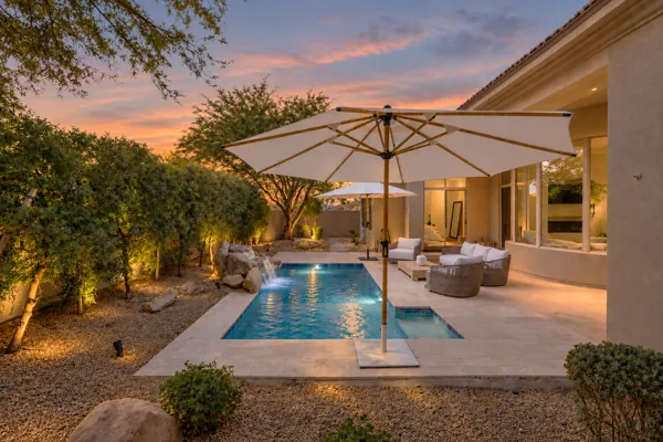 Discover stunning real estate photography showcasing a luxurious backyard oasis with a pool on E Caribbean Ln in Scottsdale, AZ.